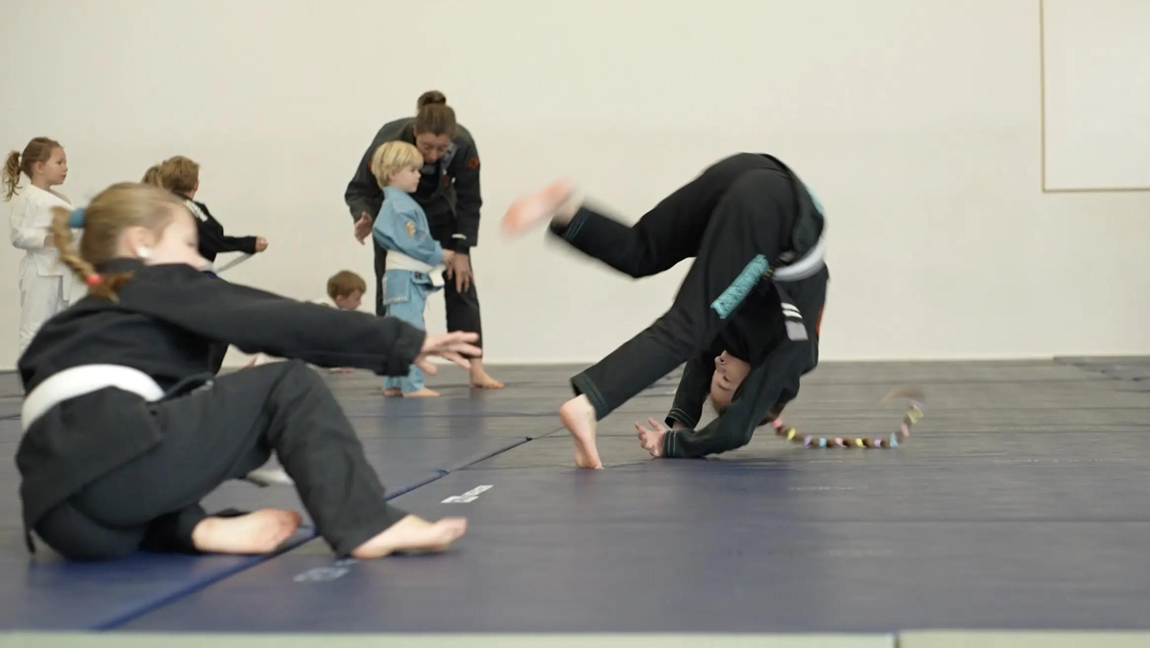Des enfants enchaînent les roulades sur le tatami