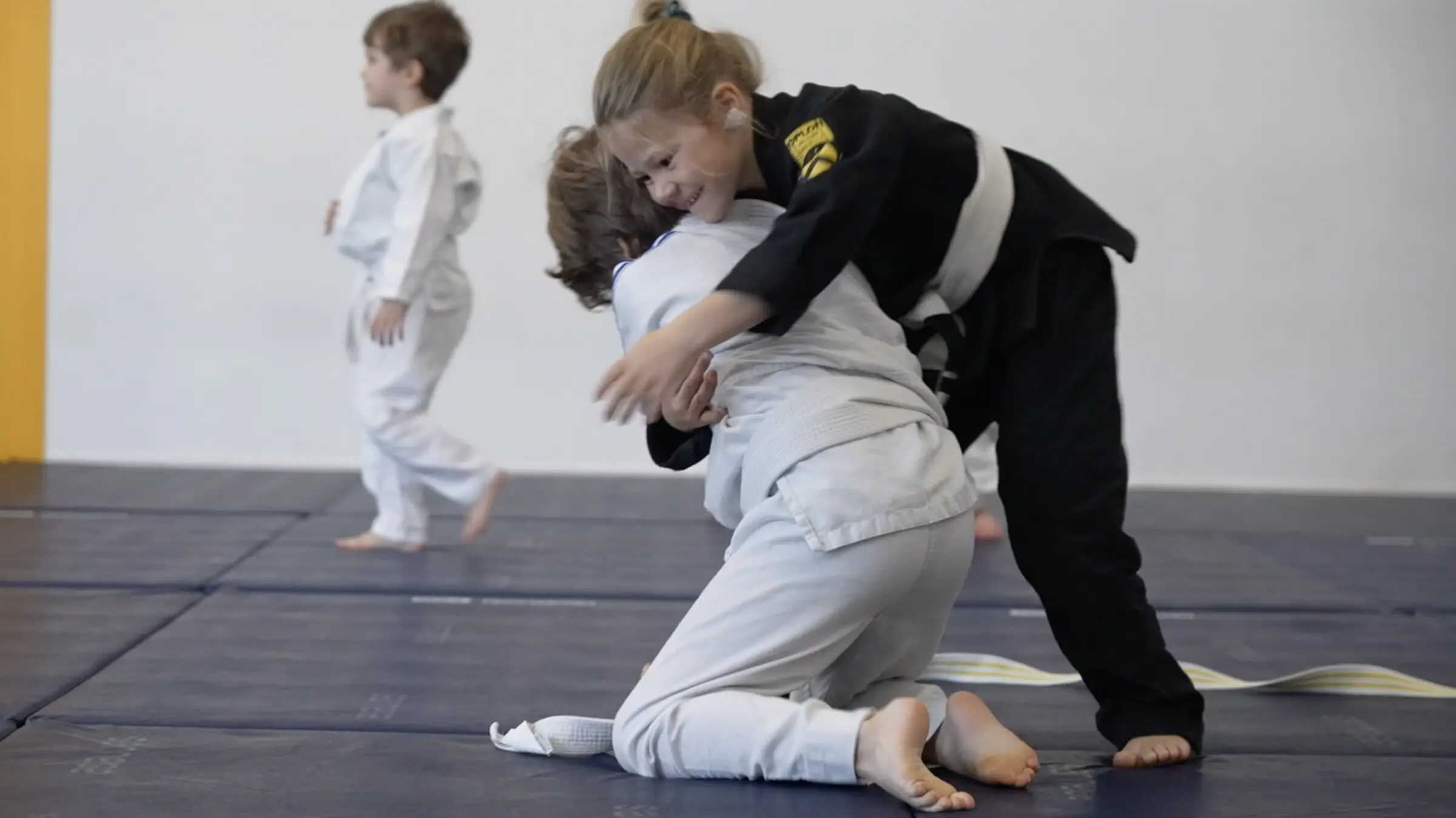 Une fillette en kimono noir fait chuter son partenaire